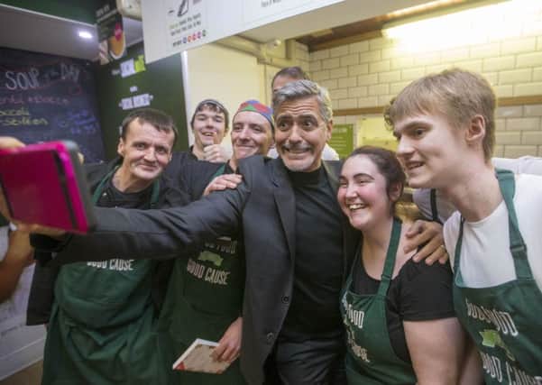 Clooney takes a selfie with the Social Bite staff. Picture: PA