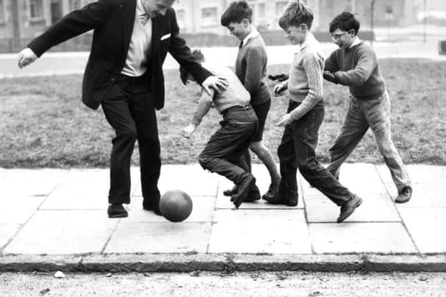 Denis Law playing with children in  Aberdeen in 1961. Picture: Newsline