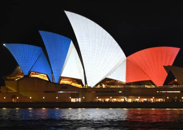 The iconic sails of the Sydney Opera House are lit in red, white and blue. Picture: AFP/Getty Images