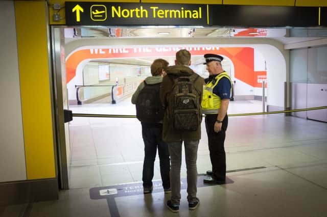 A police officers speaks with travellers at Gatwick Airport's North Terminal. Picture: PA