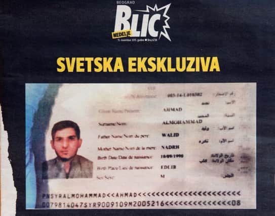 A photo of the Syrian passport found by police at the scene of one of the Paris attacks appearing in a Serbian newspaper. Picture: AFP/Getty Images