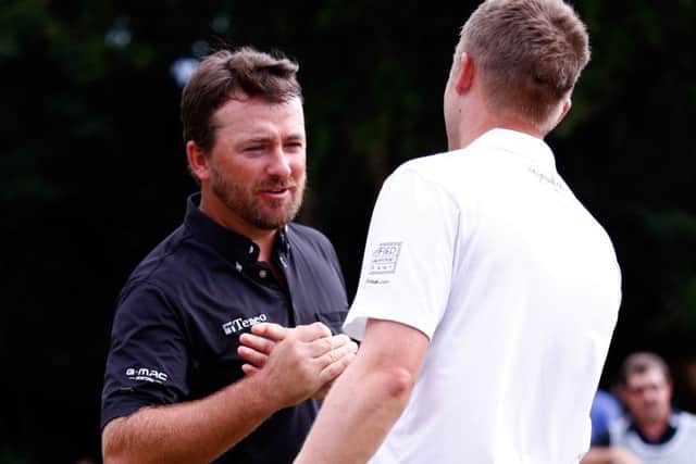 Russell Knox, right, shakes hands with Graeme McDowell after his play-off loss to the Ulsterman. Picture: Getty