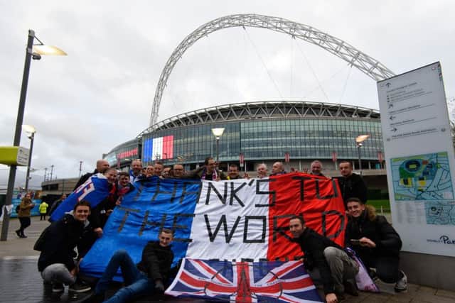 French fans posed with a french flag with the words 'Thanks To The World' as they arrived at Wembley Stadium ahead of tonight's match. Picture: Getty
