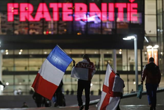 Supporters carrying England and French national flags arrive for the match. Picture: AP