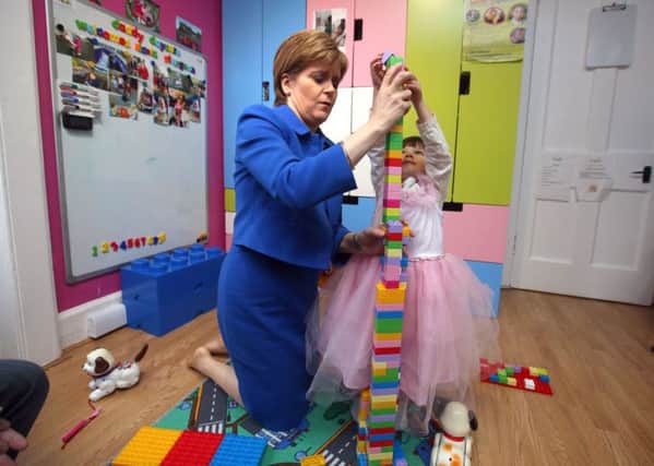 First Minister Nicola Sturgeon plays with Miriam, three, during a visit to Daddy Daycare in Edinburgh yesterday. Picture: PA