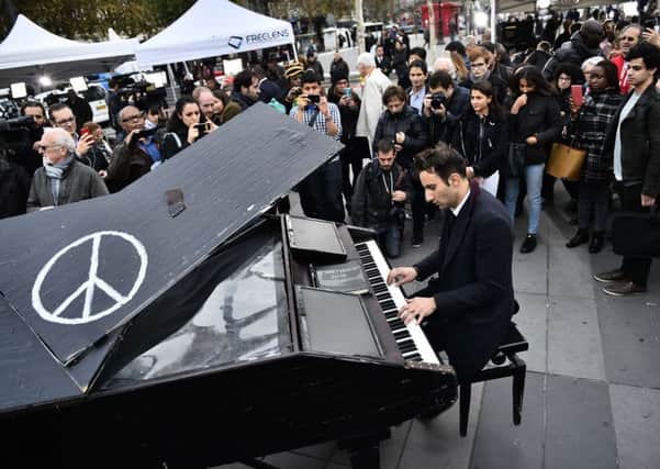 Davide Martello plays John Lennon's Imagine outside the Bataclan in Paris. Picture: Getty