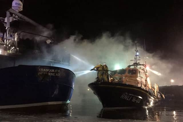 The RNLI took firefighters out to distinguish the fire on board Tranquility. Picture: Hemedia