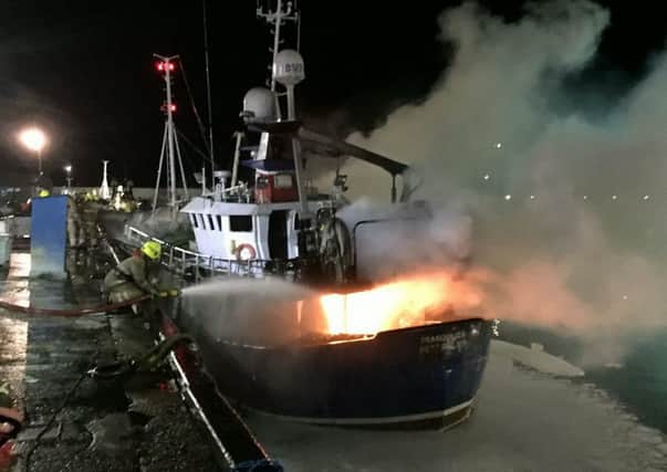 The dramatic moment a man was rescued from a harbour as fire fighters tackled a raging blaze on a boat called Tranquility in Peterhead. Picture: Hemedia