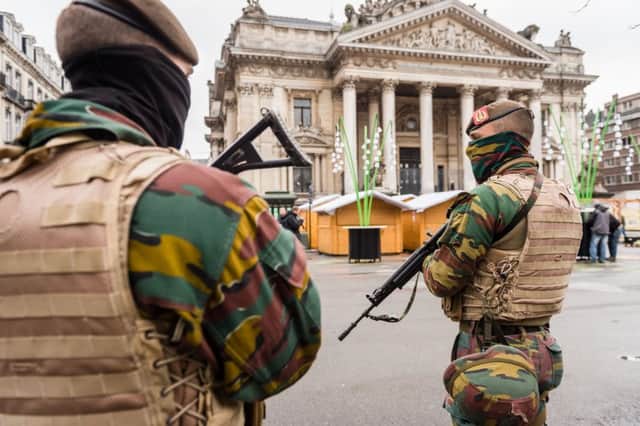 Belgian Army soldiers patrol near Christmas huts in front of the old Brussels' stock exchange yesterday. Picture: AP