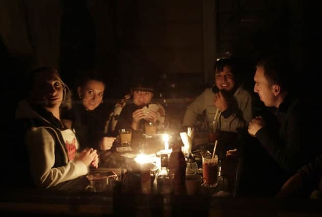 People play cards by candle light in Simferopol. Crimea declared a state of emergency after its main electricity lines were blown up. Picture: Getty