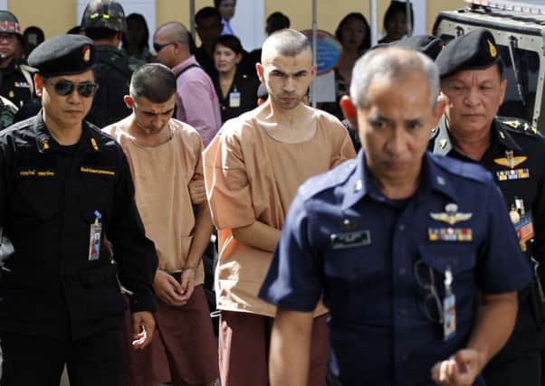 Police officers escort suspects in the blast at Erawan Shrine, Bilal Mohammad, centre front, and Mieraili Yusufu, rear centre, as they arrive at a military court in Bangkok. Picture: AP
