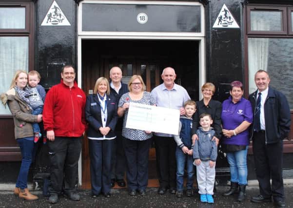 Tony Green (holding the cheque, right) presents nearly £2500 to NHS Tayside Transplant Coordinator Irene Russell (left) earlier this month. The Renal Unit at Ninewells Hospital had helped son Anthony Green (pictured with red fleece) after Tony donated his kidney to his son. Photo: NHS Tayside