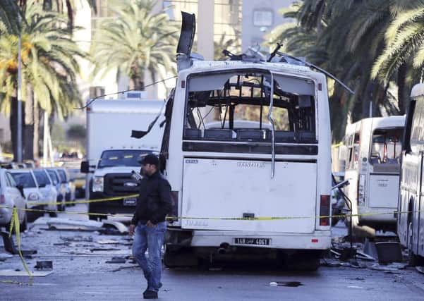 A man walks past the bus that exploded Tuesday in Tunis. Picture: AP