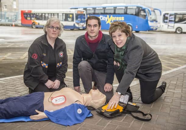 Councillors Lesley Hinds and Adam McVey join Annemarie Pattison of St Andrew's First Aid to demonstrate a new defibrillator at Edinburgh Bus Station. New research suggests only nine per cent of Scots know how to use one of the machines