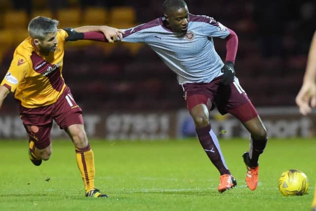 Motherwell's Keith Lasley (left) battles with Arnaud Djoum. Picture: SNS