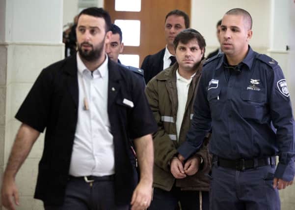 Yosef Haim Ben David, centre, is escorted by Israeli policemen at the district court in Jerusalem. Picture: AFP/Getty Images
