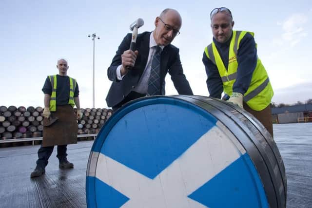 John Swinney hammers the bung into a cask to mark the opening of a new £18m Diageo cask filling store. Picture: Contributed