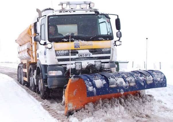 A Transport Scotland gritter battles the elements to salt a road.