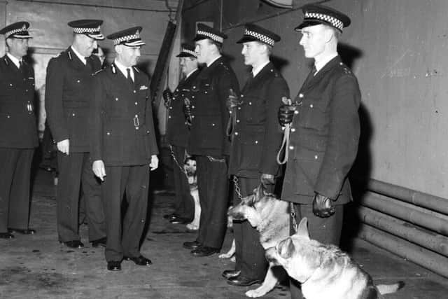 The Edinburgh City Police annual inspection in Forrest Road Drill Hall in November 1962. Thomas Renfrew chats to a policeman with his Alsatian police dog