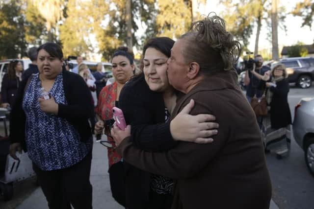 A woman kisses her sister, centre, a survivor of a shooting at a community centre in San Bernardino. Picture: AP