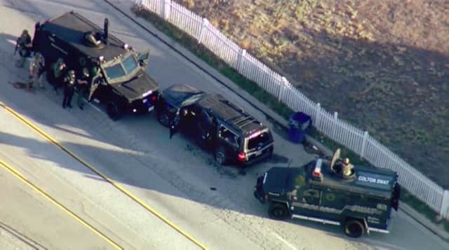 Armored vehicles surround an SUV following the shootout in San Bernardino. Picture: AP