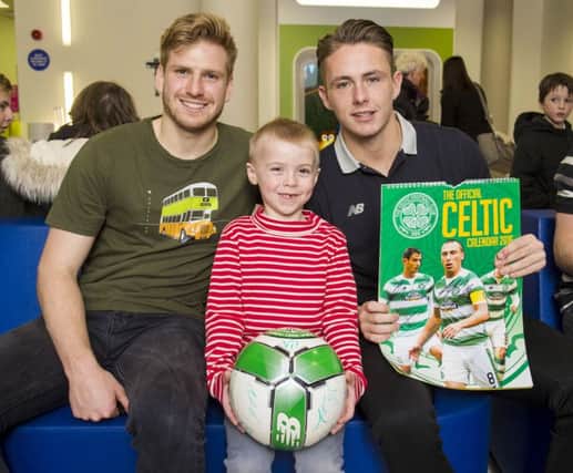 Scott Allan, right, and team-mate Stuart Armstrong visit Thomas Bennie as the Celtic squad handed over Christmas gifts at Glasgows Royal Hospital for Children. Picture: SNS