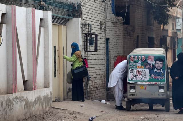 A woman and elderly man leave the house of Gulzar Ahmed Malik. Picture: AFP/Getty