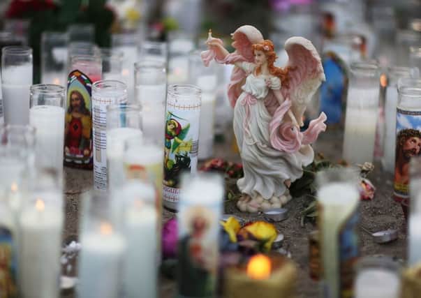 An angel statue among candles at a makeshift memorial near the Inland Regional Center in San Bernardino, California. Picture: Getty