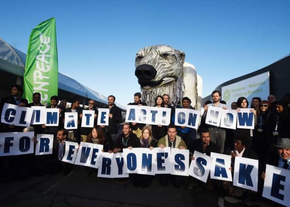 Activists hold signs in front of Greenpeace's giant puppet polar bear during a protest at the UN climate change conference in Paris. Picture: AFP/Getty Images