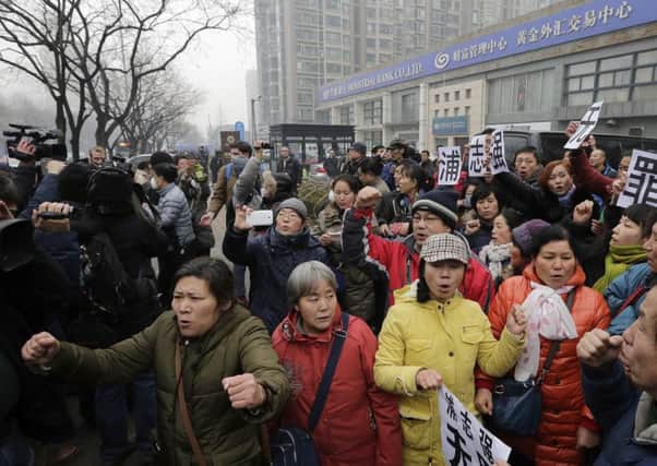 Supporters of prominent rights lawyer Pu Zhiqiang chant slogans as they gather near the Beijing Second Intermediate People's Court in Beijing.
Picture by  AP Photo/Andy Wong)