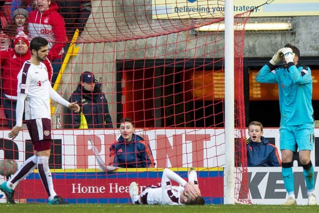 Dejection for Hearts' Jordan McGhee (grounded) after his handball gifts Aberdeen a penalty. Picture: SNS