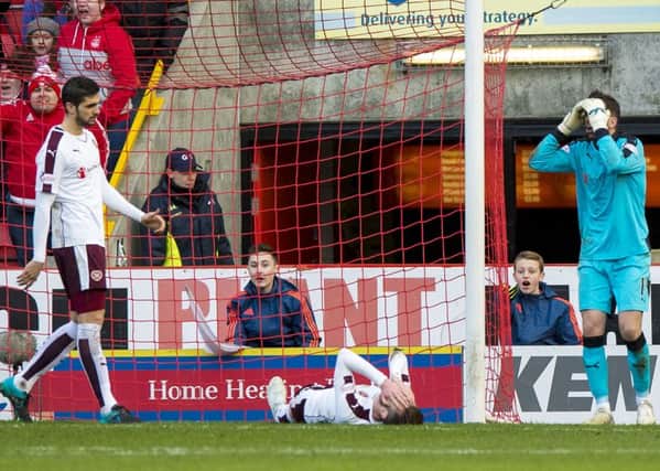 Dejection for Hearts' Jordan McGhee (grounded) after his handball gifts Aberdeen a penalty. Picture: SNS