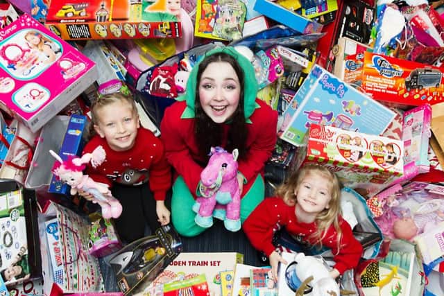 Orla and Mara deliver their presents to Twinkle McSparkle the Elf. Picture: John Devlin
