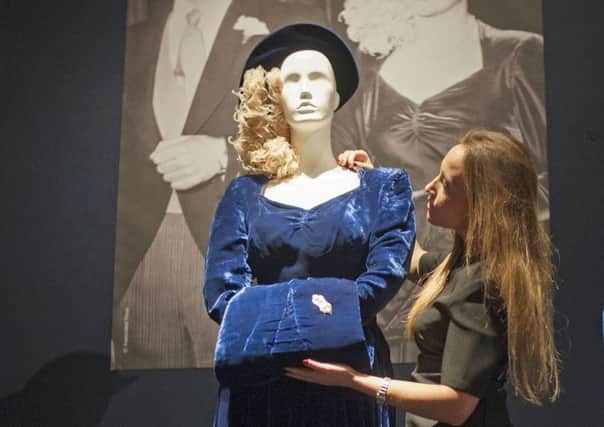 A Christie's staff member adjusts Margaret Thatcher's wedding outfit. Picture: PA