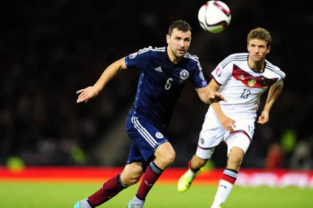 James McArthur vies for the ball with Germany's Thomas Muller at Hampden in September. Picture: Michael Gillen