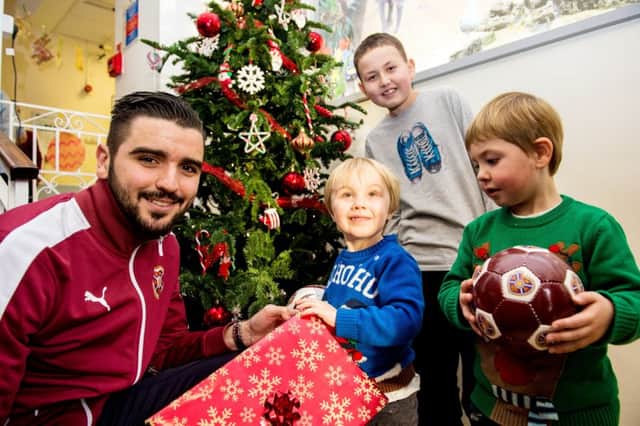 Hearts' Alim Ozturk hands out presents to Sam Graham, Mason Riddell and Kieran Spencer at the Royal Hospital for Sick Children.  Picture: Ross Parker/SNS