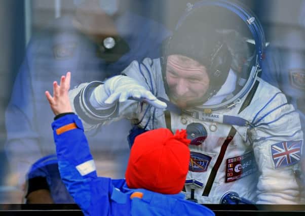 Tim Peake gestures to his child from a bus at the Baikonur cosmodrome.  Picture: Kirill Kudryatsev/Getty