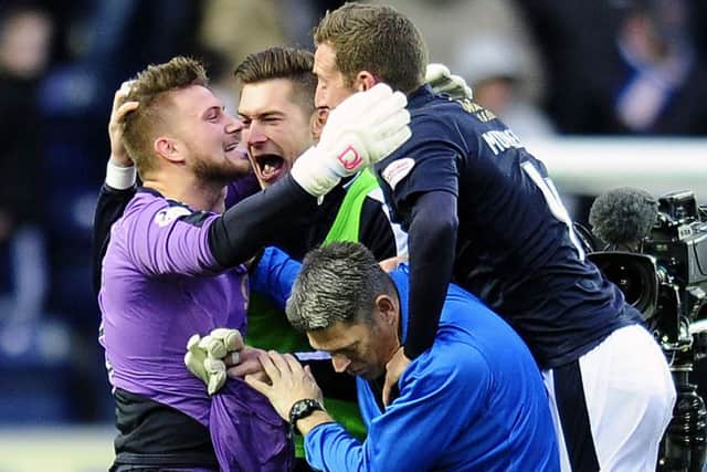 Falkirk's penalty save hero Danny Rogers is mobbed by his team-mates. Picture: Michael Gillen