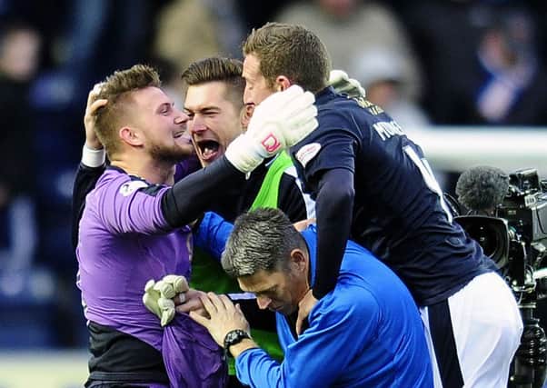 Falkirk's penalty save hero Danny Rogers is mobbed by his team-mates. Picture: Michael Gillen