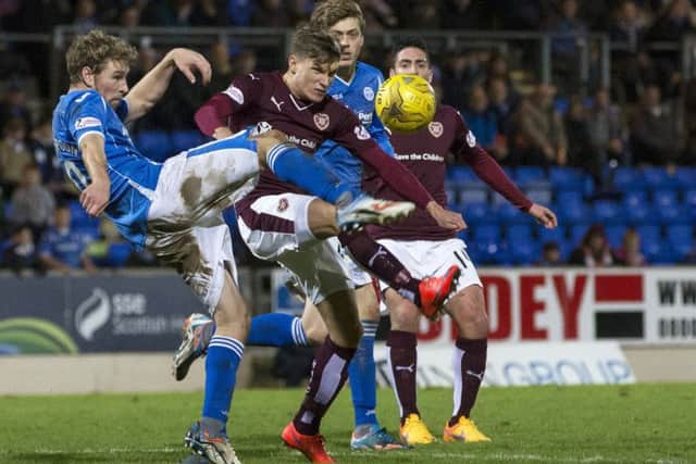St Johnstone's David Wotherspoon (left) clears the ball under pressure from Hearts' Gavin Reilly. Picture: SNS