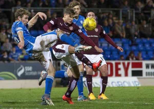 St Johnstone's David Wotherspoon (left) clears the ball under pressure from Hearts' Gavin Reilly. Picture: SNS