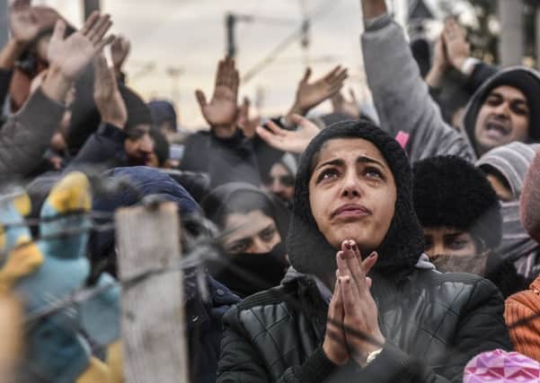 Migrants protest behind a fence against restrictions restricting passage at the Greek-Macedonian border. Picture: Getty
