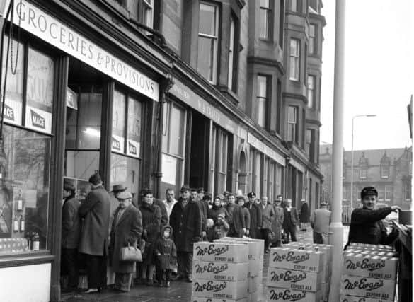December 29, 1965: Customers queue outside Mr Munro's shop in Brandon Terrace, Stockbridge, eager to buy supplies for Hogmanay. Crates of McEwan's Export wait to be loaded inside. Picture: Joe Steele