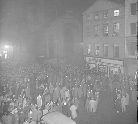Hogmanay 1957: Revellers stand outside the Tron Kirk awaiting the stroke of midnight. The former Alexandra Hotel and B Hyam store can be seen on the right. Picture: TSPL