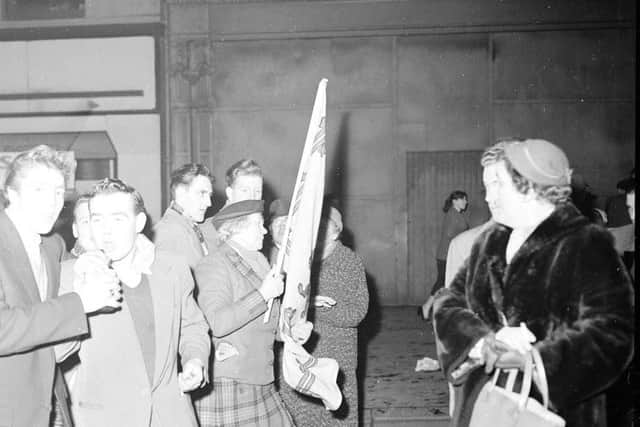 Hogmanay 1957: Wendy Wood, a well-known campaigner for Scottish independence, carries the Royal Standard of Scotland along the High Street. Picture: TSPL