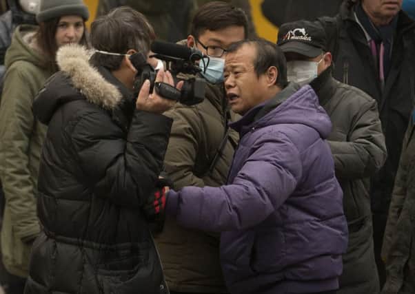 A man pushes a videojournalist, left, near the court where human rights lawyer Pu Zhiqiang was sentenced in Beijing. Picture: AP