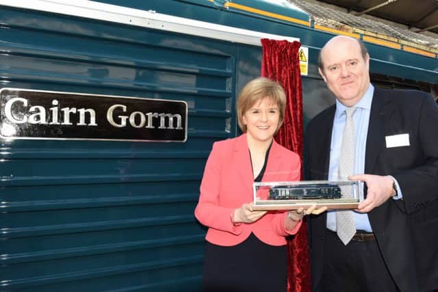 Soames and First Minister Nicola Sturgeon hold a model engine to 
mark Sercos high-profile rebranding of the Caledonian Sleeper service