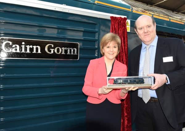Soames and First Minister Nicola Sturgeon hold a model engine to 
mark Sercos high-profile rebranding of the Caledonian Sleeper service