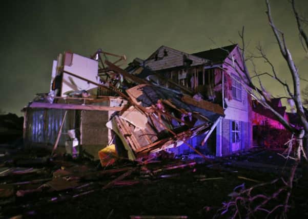 Debris lies on the ground near a home that was heavily damaged. Picture: AP