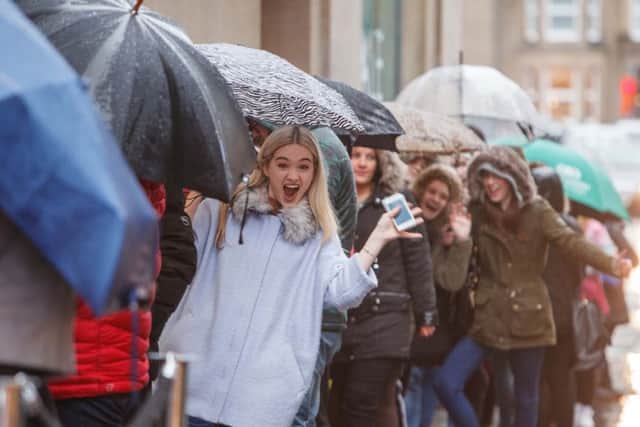 Shoppers queue in the rain outside shops on Boxing Day. Picture: Toby Williams